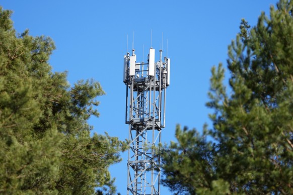 ARCHIV - 08.03.2022, Brandenburg, Wandlitz/Ot Basdorf: Ein Mast mit Mobilfunk-Antennen steht zwischen Kiefern. In Nordrhein-Westfalen funken 5G-Antennen inzwischen auf 80 Prozent der Landesfläche. (zu ...