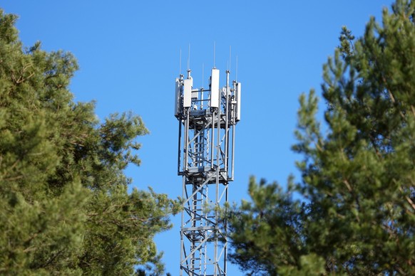 ARCHIV - 08.03.2022, Brandenburg, Wandlitz/Ot Basdorf: Ein Mast mit Mobilfunk-Antennen steht zwischen Kiefern. In Nordrhein-Westfalen funken 5G-Antennen inzwischen auf 80 Prozent der Landesfläche. (zu ...