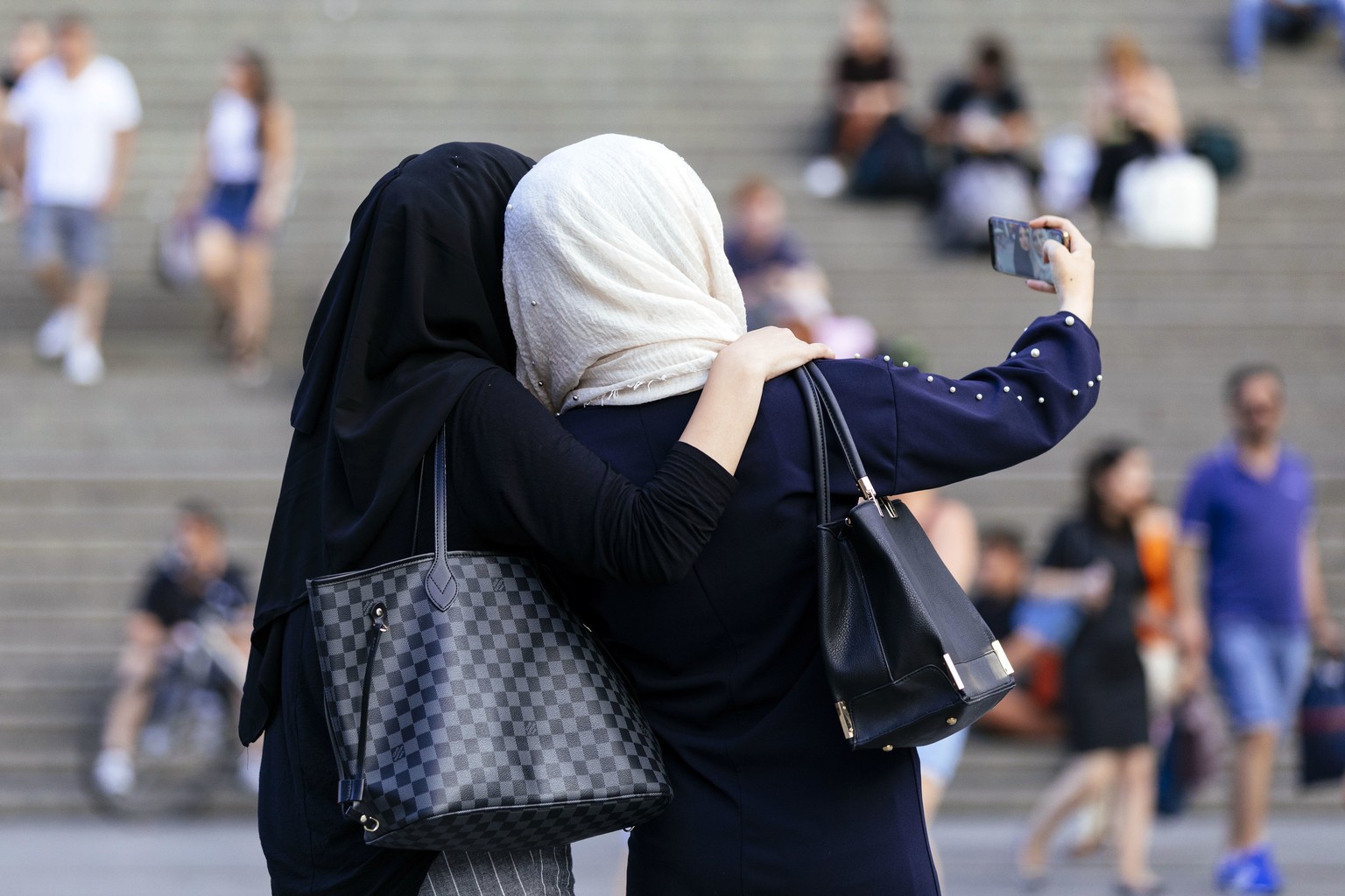 Junge Frauen mit Kopftuch vor dem Dom in Köln.