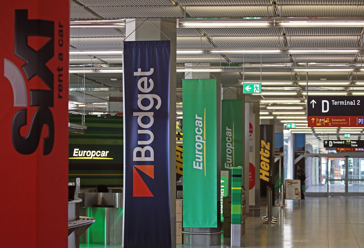 ARCHIV - 07.04.2020, Nordrhein-Westfalen, Köln: Die Schalter verschiedener Mietwagen-Anbieter am Flughafen Köln Bonn. Fast alles ist teurer geworden, doch Mietwagen für die Sommerferien sind offensich ...