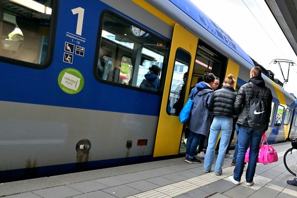 Im Bahnhof. Fahrgäste beim Ein- und Aussteigen vom Zug. Traunstein Bayern Deutschland *** In train station passengers getting on and off train Traunstein Bavaria Germany Copyright: xRolfxPossx