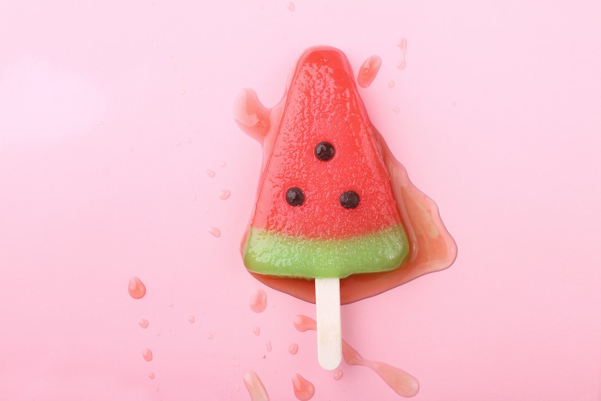 watermelon shaped ice cream pop lay on pink pastel background