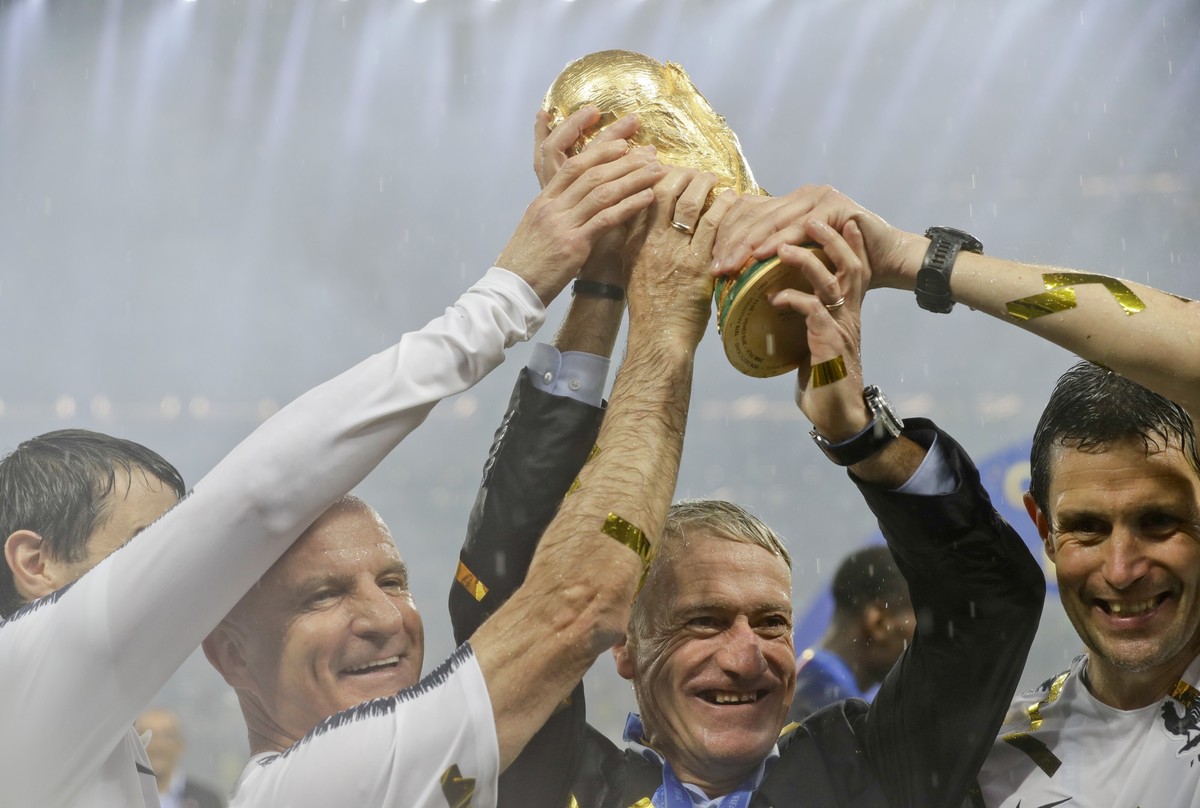 FILE - In this Sunday, July 15, 2018 file photo, France head coach Didier Deschamps, second right, holds the trophy at the end of the final match between France and Croatia at the 2018 soccer World Cu ...