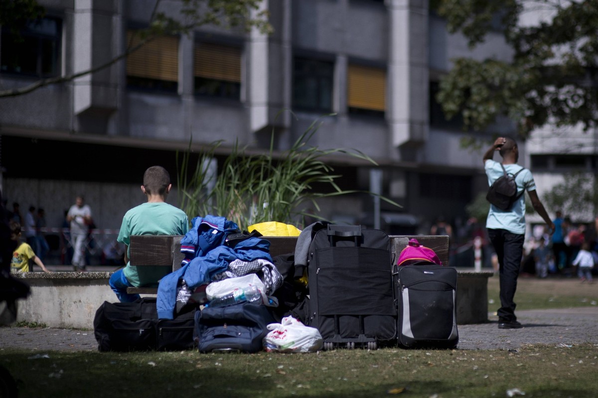 Zentrale Aufnahmeeinrichtung fuer Asylbewerber Berlin DEU, Deutschland, Germany, Berlin, 03.08.2015 Asylsuchende warten mit ihrem Gepaeck vor der Zentralen Aufnahmeeinrichtung des Landes Berlin fuer A ...