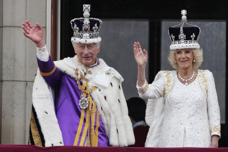 06.05.2023, Großbritannien, London: König Charles III. und Königin Camilla winken nach ihrer Krönungszeremonie vom Balkon des Buckingham Palastes aus der Menge zu. Es ist ein historisches Ereignis: Ch ...