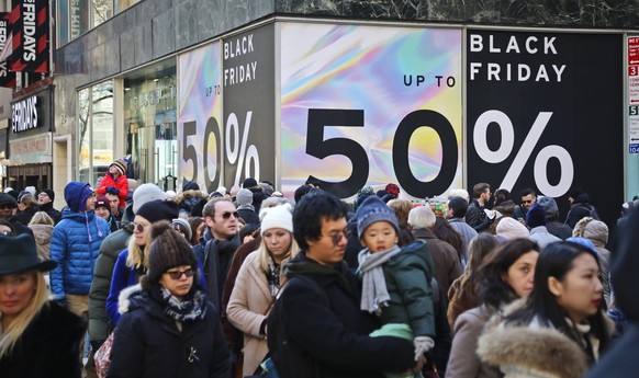 FILE - Crowds walk past a large store sign displaying a Black Friday discount in midtown New York, Friday, Nov. 23, 2018. Given higher prices and economic uncertainty, consumers face a lot of pressure ...