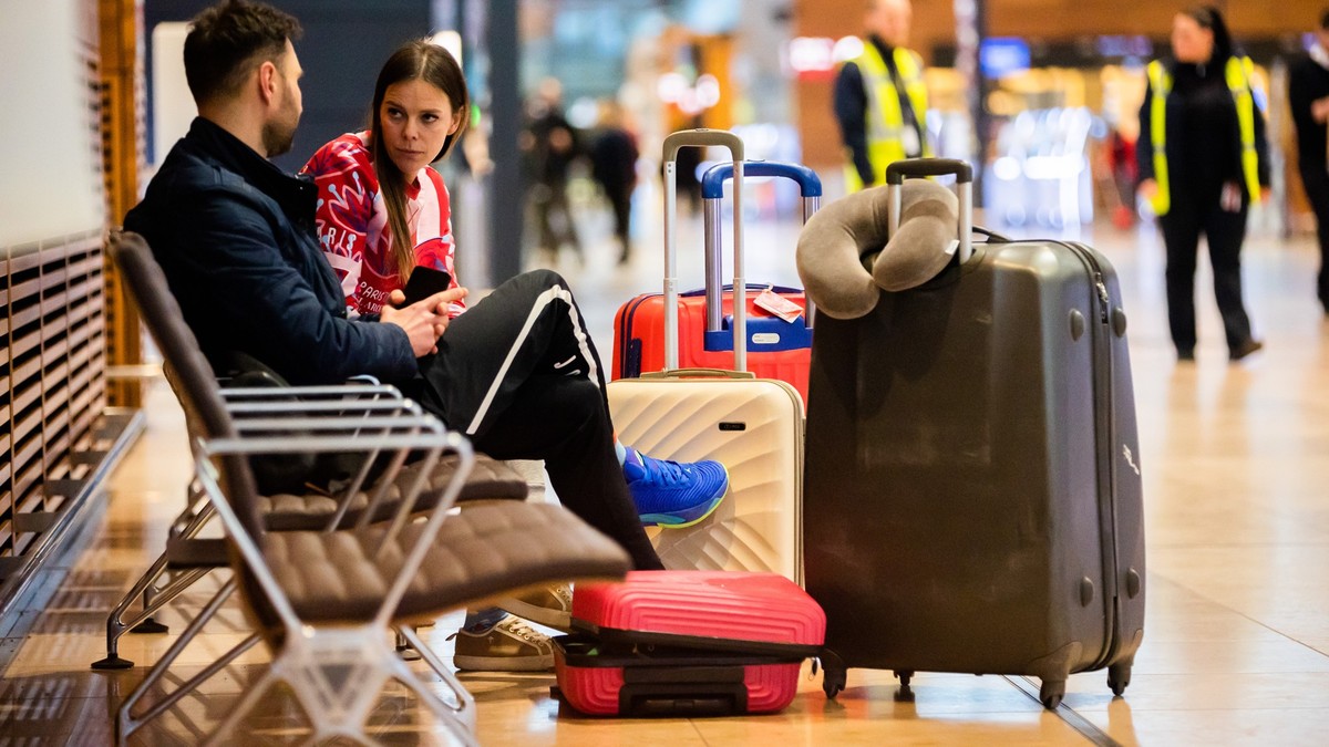 25.01.2023, Brandenburg, Schönefeld: Martin und Karoline aus Polen sitzen während eines Warnstreiks am Flughafen Berlin-Brandenburg BER. Sie wollten über Singapur nach Phuket in Thailand in den Urlaub ...