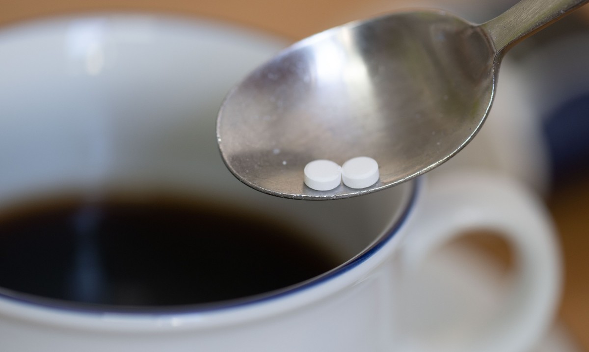PRODUKTION - 12.07.2023, Sachsen, Leipzig: Ein L�ffel mit zwei S��stofftabletten ist �ber einer Tasse Kaffee zu sehen. Ein h�ufig in Softdrinks, Joghurt und Kaugummi eingesetzter S��stoff kann laut ei ...