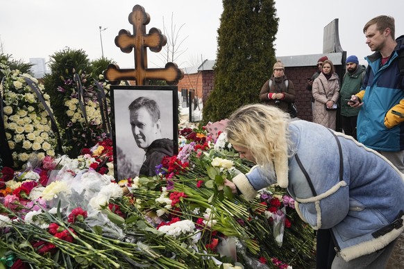 dpatopbilder - 02.03.2024, Russland, Moskau: Eine Frau legt einen Tag nach der Beerdigung von Alexej Nawalny auf dem Borisowskoje-Friedhof Blumen am Grab ab. Nawalny, der der schärfste Gegner von Präs ...