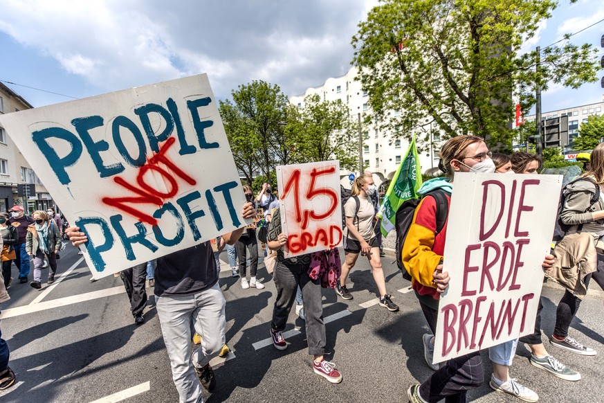 06.05.2022, Nordrhein-Westfalen, Bochum: Demonstranten halten bei einer Kundgebung der Bewegung Fridays for Future Transparente mit der Aufschrift &quot;People Not Profit&quot; und &quot;Die Erde Bren ...