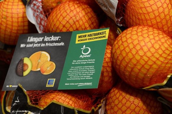 Orangen liegen mit einem Hinweisschild in der EDEKA-Filiale Paschmann. Sie sind mit einer hauchdünnen, essbare Schutzschicht, die direkt auf die Schale der Früchte aufgetragen wird, überzogen.