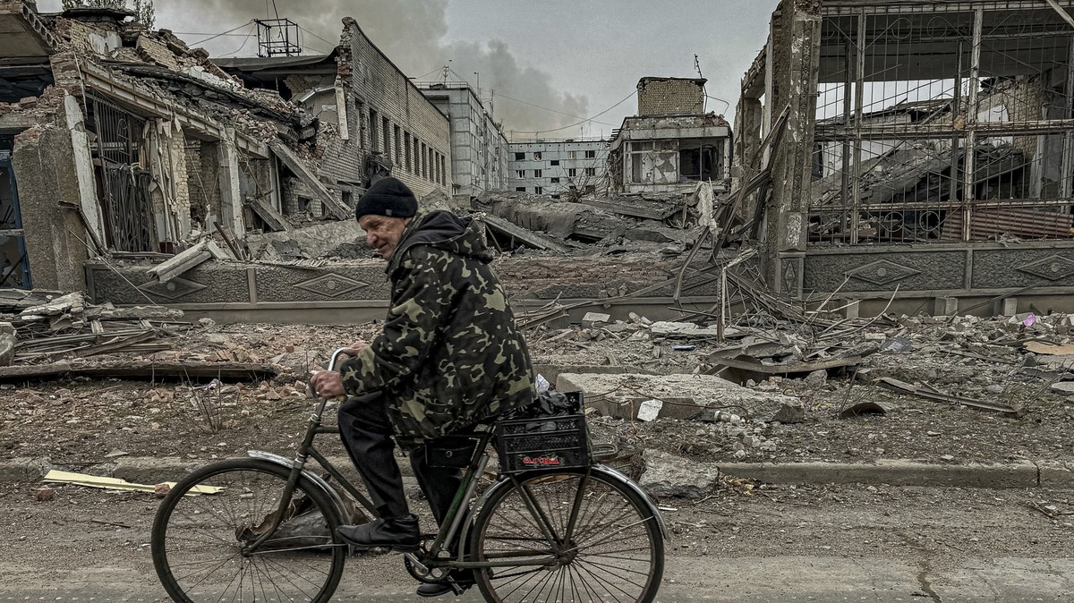07.11.2024, Ukraine, Kurachowe: Ein Mann fährt auf einem Fahrrad vor dem Postamt, das durch einen russischen Luftangriff zerstört wurde. Foto: Anton Shtuka/AP/dpa +++ dpa-Bildfunk +++