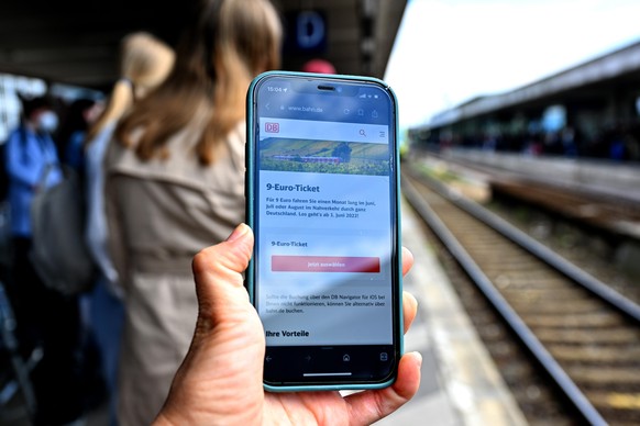 Verkehr, Zug, 9-Euro-Ticket: Eine Frau bucht über die App eines Smartphones das 9-Euro-Ticket für die RE1 nach Norddeich Mole. Mit der von der Bundesregierung subventionierten Fahrkarte können Reisend ...