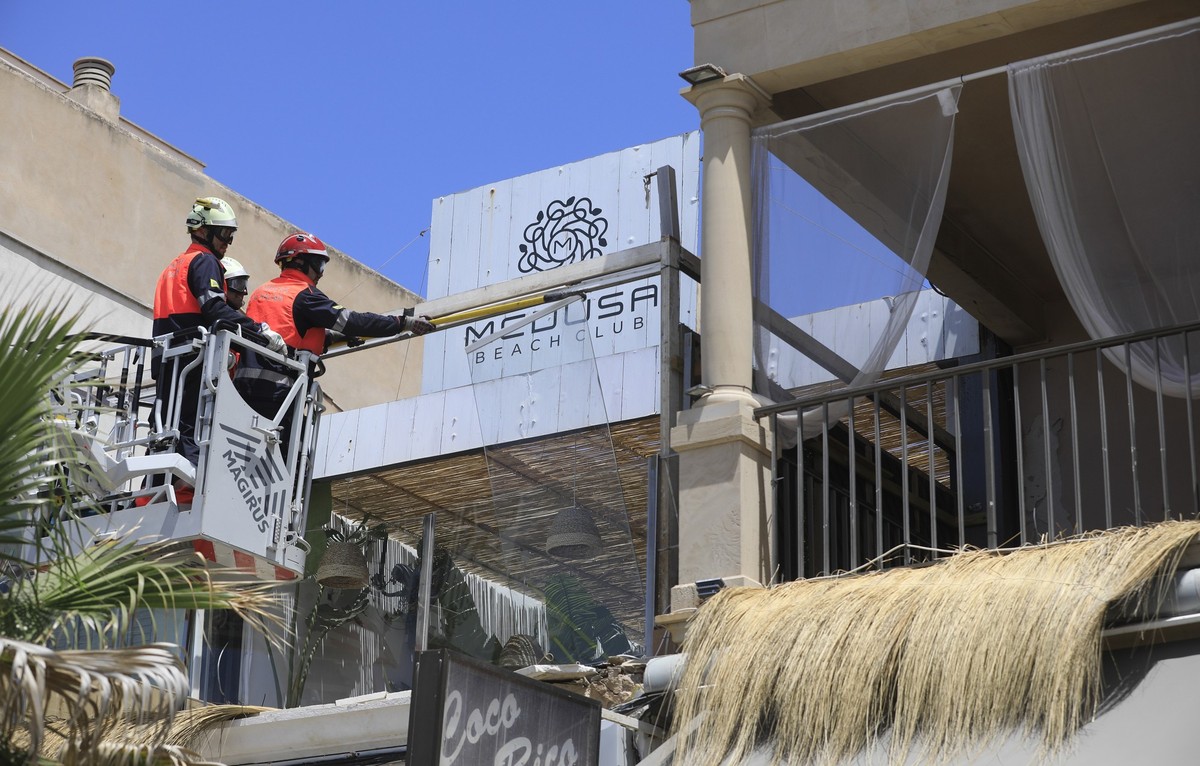 ARCHIV - 24.05.2024, Spanien, Palma: Feuerwehrleute arbeiten nach dem Einsturz am Gebäude des Medusa Beach Club. Zwei deutsche Frauen und zwei weitere Personen sind beim Einsturz des Restaurants an de ...