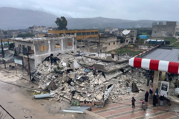 dpatopbilder - 06.02.2023, Syrien, Azmarin: Menschen durchsuchen die Trümmer eines eingestürzten Gebäudes in der Stadt Azmarin in der Provinz Idlib im Norden Syriens. Zwei heftige Erdbeben haben kurz  ...