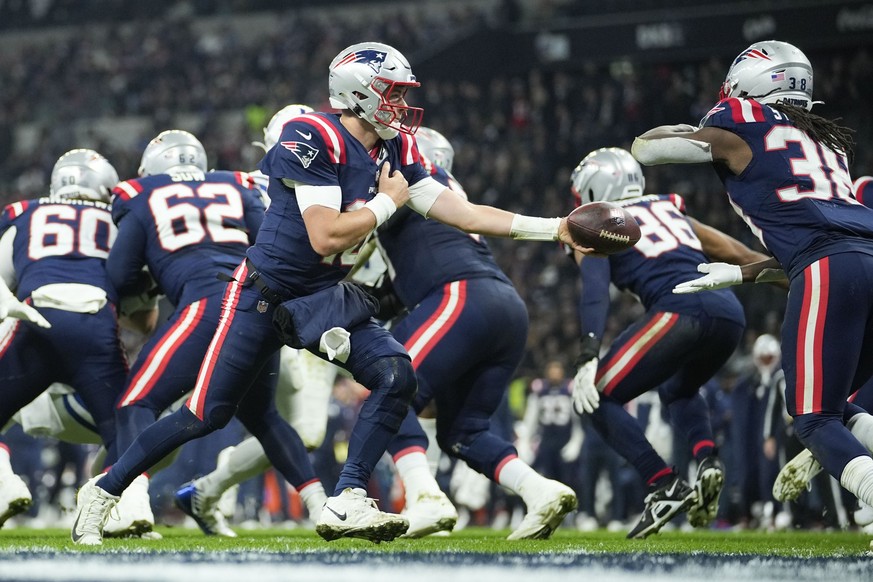 New England Patriots quarterback Mac Jones (10) hands off to running back Rhamondre Stevenson (38) in the second half of an NFL football game against the Indianapolis Colts in Frankfurt, Germany Sunda ...