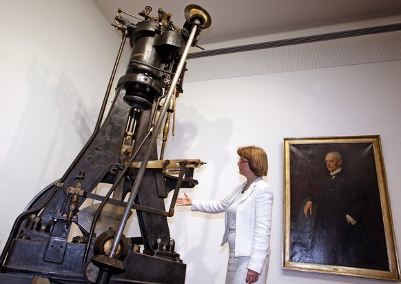 Der Erfinder und sein Werk. Der erste Selbstzündermotor vor einem Bild seines Erfinders Rudolf Diesel.