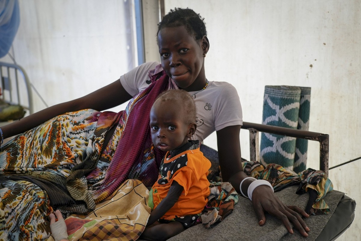 FILE - A mother sits with her malnourished baby at a hospital run by Medicines Sans Frontieres (Doctors Without Borders) in Old Fangak in Jonglei state, South Sudan on Dec. 28, 2021. A new report rele ...