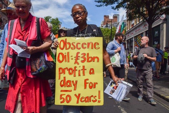 Ein Demonstrant hält ein Plakat, auf dem steht, dass die Ölkonzerne seit 50 Jahren täglich 3 Milliarden Pfund Gewinn machen, während einer Demonstration in Bloomsbury. Demonstranten von Just Stop Oil, ...