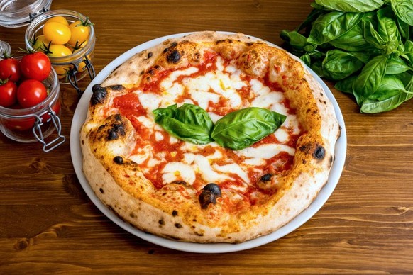 A delicious and tasty Italian pizza Margherita with fresh tomatoes, buffalo mozzarella and extra virgin olive oil, strictly cooked in a wood oven, according to the original tradition of Naples. In 201 ...