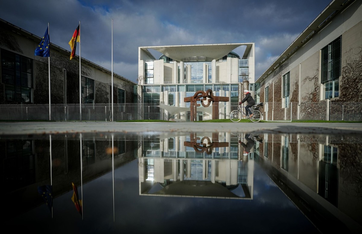 27.03.2023, Berlin: Das Bundeskanzleramt wird von der Sonne am Morgen unter dunklen Wolken angestrahlt. Seit dem 26.03.2022 tagen hier die Spitzenvertreter von SPD, Bündnis 90/Die Grünen und FDP und b ...