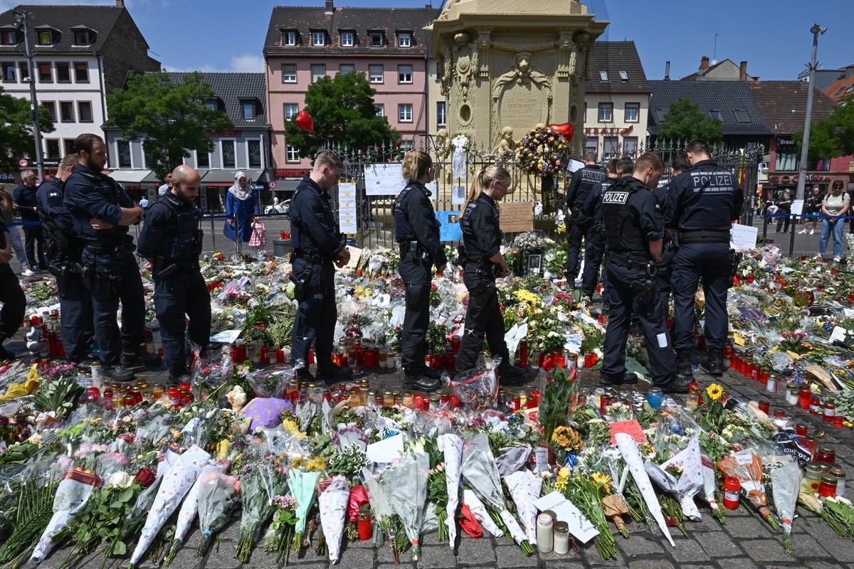 ARCHIV - 07.06.2024, Baden-W�rttemberg, Mannheim: Polizisten stehen auf dem Marktplatz vor einem Gedenkplatz f�r einen bei einer Messerattacke get�teten Polizisten. Eine Woche zuvor wurde auf dem Plat ...