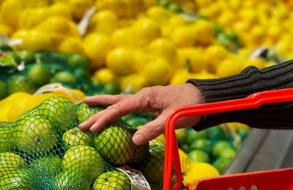 SYDNEY, AUSTRALIA - AUGUST 16: A customer selects limes at a fruit stand in the central business district on August 16, 2022 in Sydney, Australia. According to Australia&#039;s Bureau of Statistics, A ...
