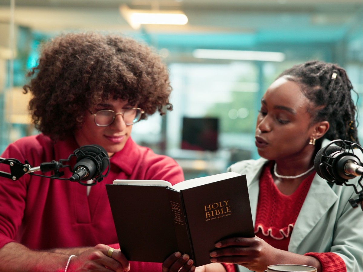 Bible, microphone and radio with people in recording studio for religious study or streaming. Book, podcast and reading with Christian influencer team on talk show for belief, faith or religion
