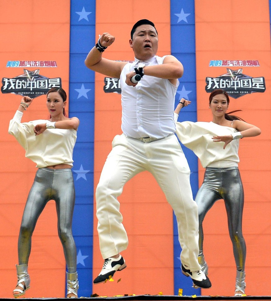 Korean singer Park Jae-sang, better known as Psy (C), performs at the launch ceremony of the reality TV talent show, Superstar China, in Wuhan city, central Chinas Hubei province, 21 June 2013. Photo: ...