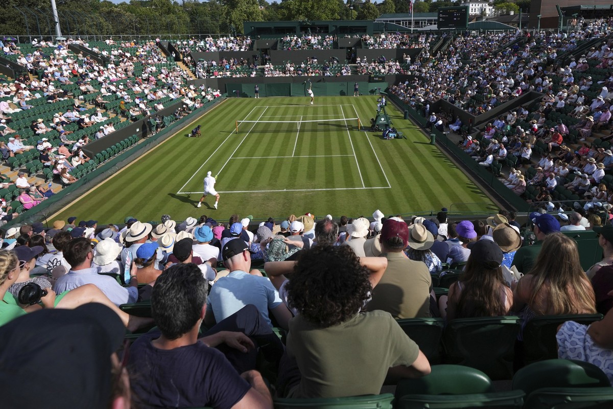 Ben Shelton of the U.S., rear, serves the ball to Alex Bolt of Australia during their first round men&#039;s single match at the Wimbledon Tennis Championships in London, Tuesday, July 1, 2025.(AP Pho ...