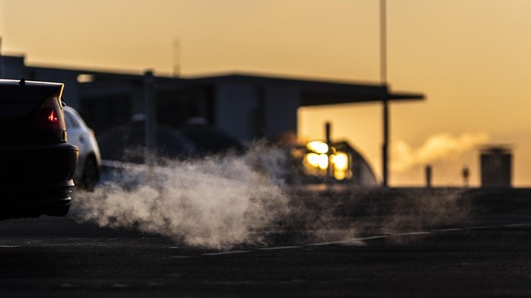 Abgase von einem Auto zeichnen sich ab vor der untergehenden Sonne in Berlin, 11.01.2022. Copyright: Florian Gaertner/photothek.de