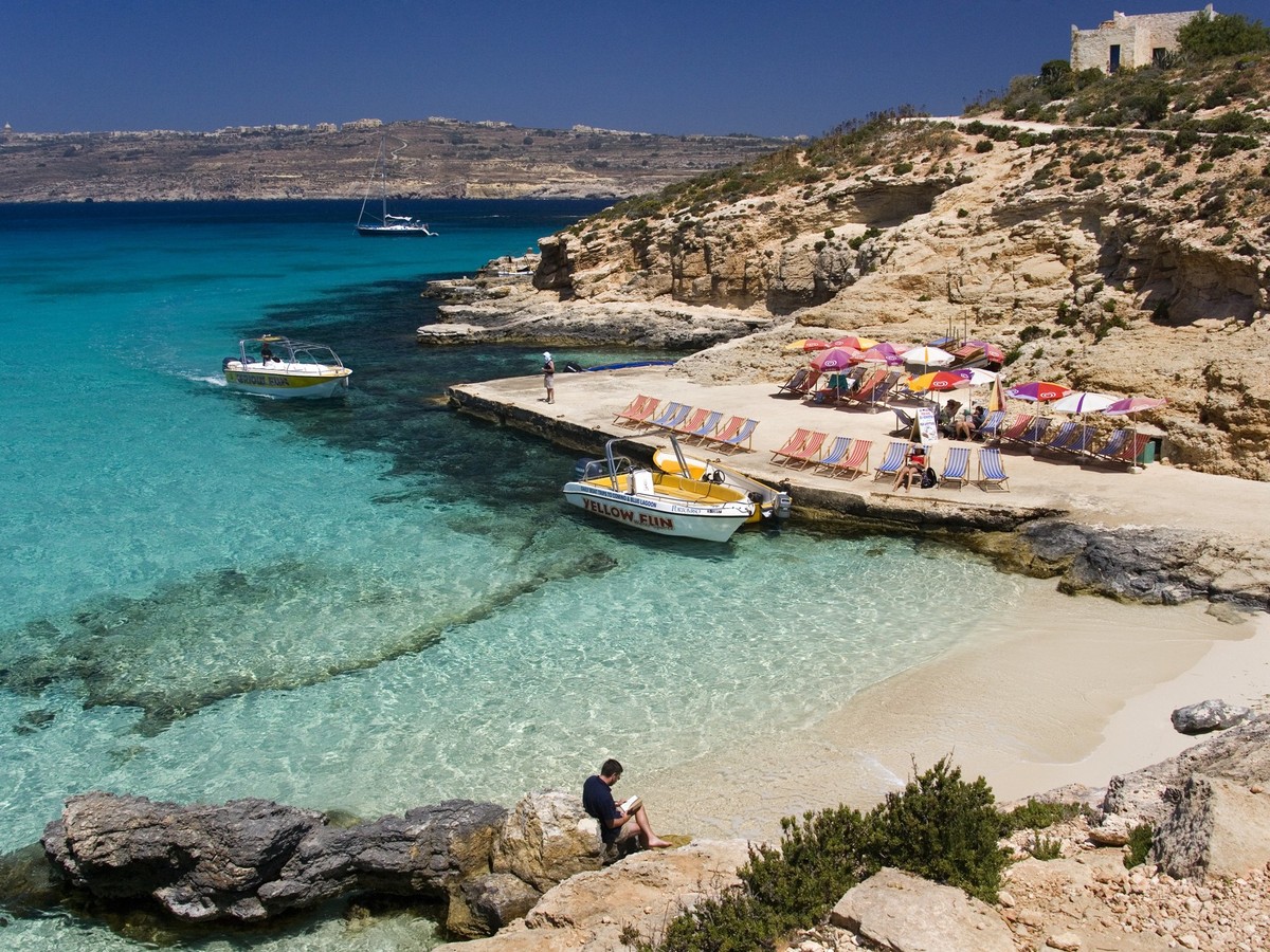 Malta - The Blue Lagoon on the tiny island of Comino with Gozo in the distance, The Blue Lagoon on the tiny island of Comino with Gozo in the distance. Malta, The Blue Lagoon on the tiny island of Com ...