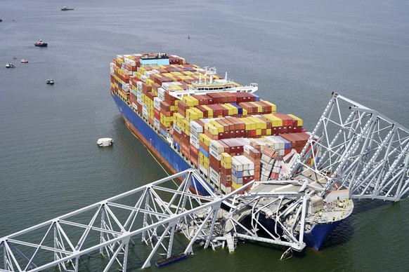 HANDOUT - 26.03.2024, USA, Baltimore: Auf diesem von der Maryland National Guard veröffentlichten Luftbild steckt das Containerschiff «Dali» unter einem Teil der Francis Scott Key Bridge fest. In der  ...