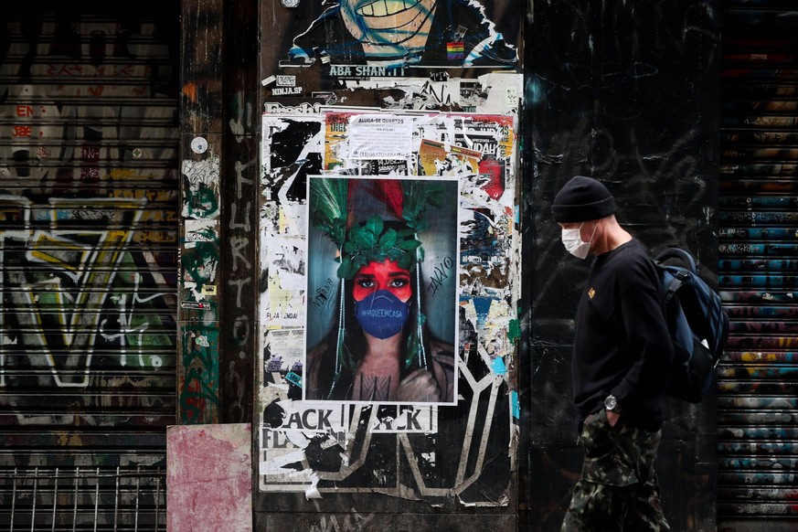 A young man walks in front of an artistic poster promoting the use of masks, in Sao Paulo, Brazil, 13 May 2020. With more than 12,400 deaths from the coronavirus, Brazil, the Latin American epicenter  ...