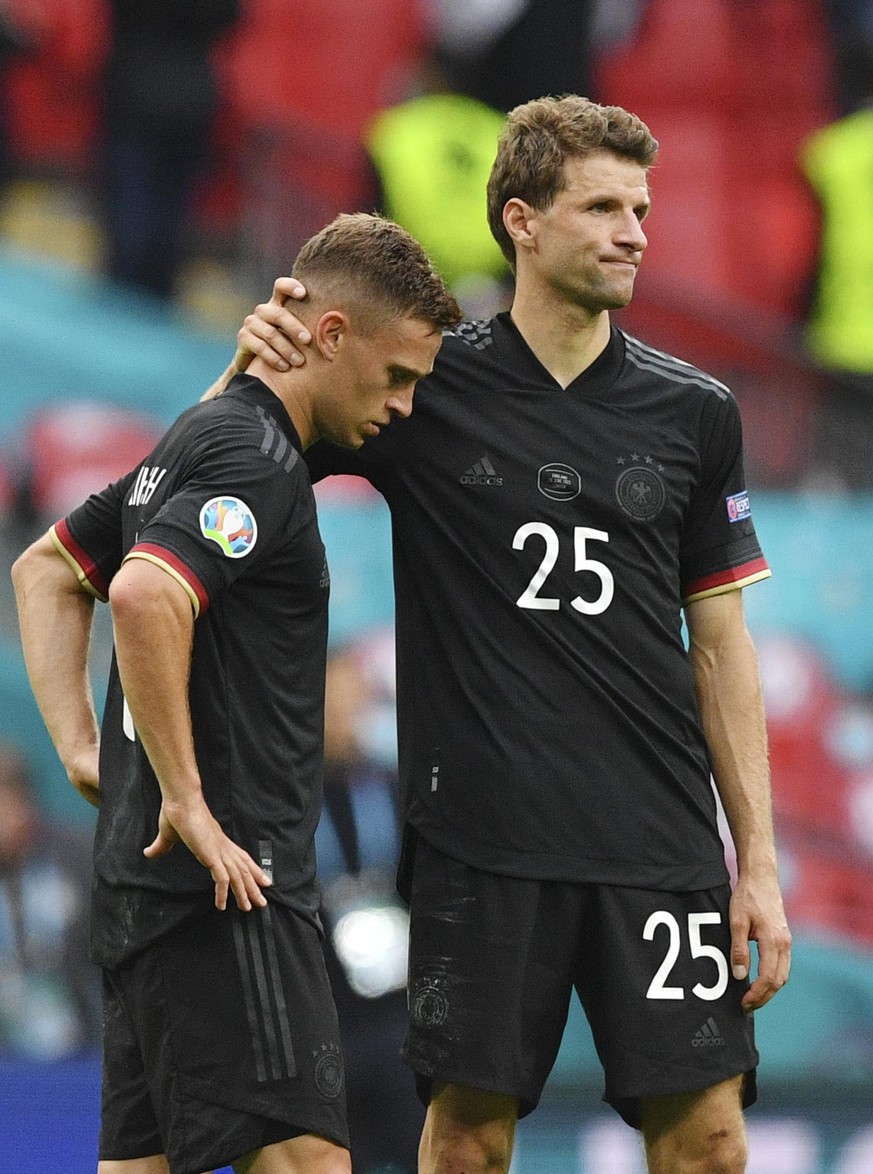 Deutschlands Joshua Kimmich (l) und Thomas Müller stehen nach dem Spiel enttäuscht auf dem Rasen.