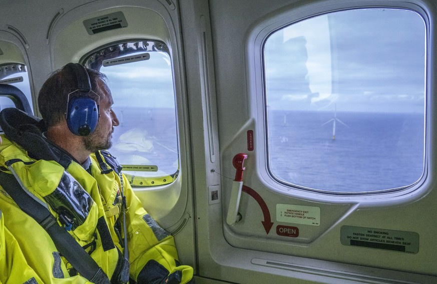 23.08.2023, Norwegen, Bergen: Kronprinz Haakon von Norwegen betrachtet den schwimmenden Offshore-Windpark Hywind Tampen vor seiner offiziellen Eröffnung von einem Hubschrauber aus. Foto: Ole Berg-Rust ...