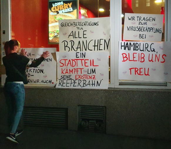 Eine Prostituierte klebt ihr Plakat an einen Schnellimbiss.