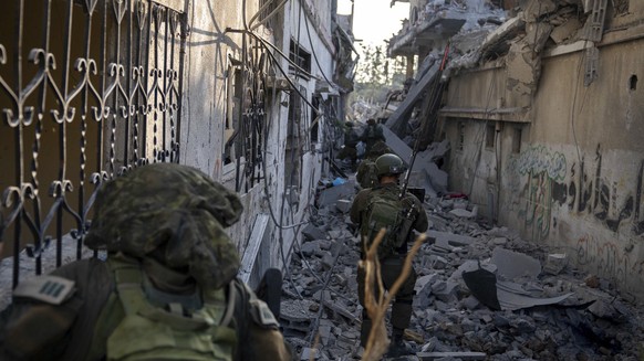 HANDOUT - 03.11.2023, Palästinensische Gebiete, Gazastreifen: Auf diesem undatierten Foto, das vom israelischen Militär zur Verfügung gestellt wurde, gehen israelische Soldaten zwischen zerstörten Häu ...