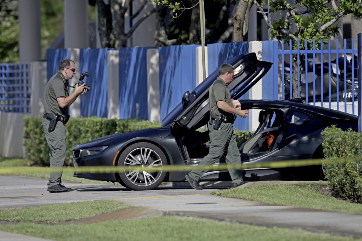 Investigators surround a vehicle after rapper XXXTentacion was shot on Monday, June 18, 2018, in Deerfield Beach, Fla. The Broward Sheriff's Office says the 20-year-old rising star was pronounced ...