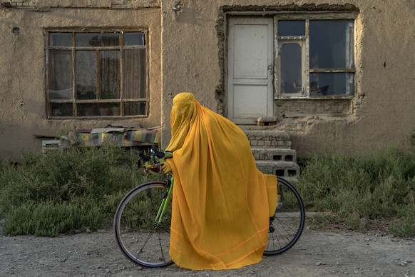 ARCHIV - 19.09.2022, Afghanistan, Kabul: Eine afghanische Frau agiert mit einem Fahrrad. Die herrschenden Taliban haben Frauen nicht nur den Sport verboten, sondern sie auch von den meisten Schulen un ...