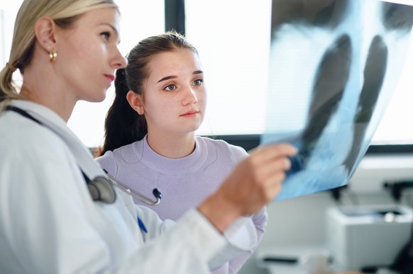Young woman doctor showing x-ray image of lungs to her patient. Young woman doctor showing x-ray image of lungs to the patient. model released Copyright: xx HHH BOJNICE HOSPITAL DOC OFFICE 2022 HHH 09 ...