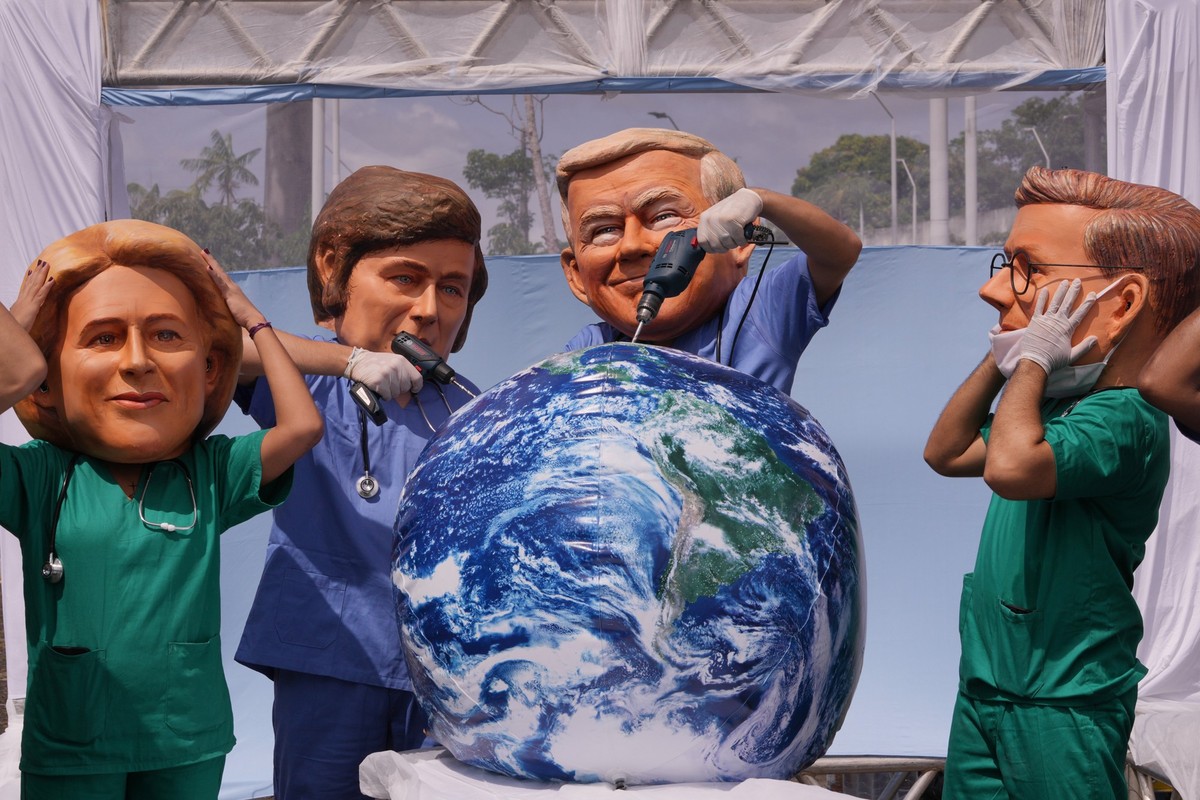 Demonstrators with the likeness of Argentina President Javier Milei, center left, and President Donal Trump, center right, pretend to drill into the Earth during the COP30 U.N. Climate Summit, Thursda ...