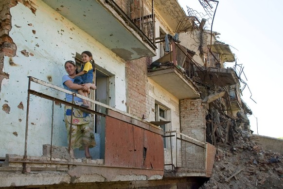 Bildnummer: 54172999 Datum: 31.05.2006 Copyright: imago/ITAR-TASS
GROZNY, CHECHNYA, RUSSIA. Mother holds daughter in her arms as she stands on the balcony of a dilapidated house in Grozny. PUBLICATION ...