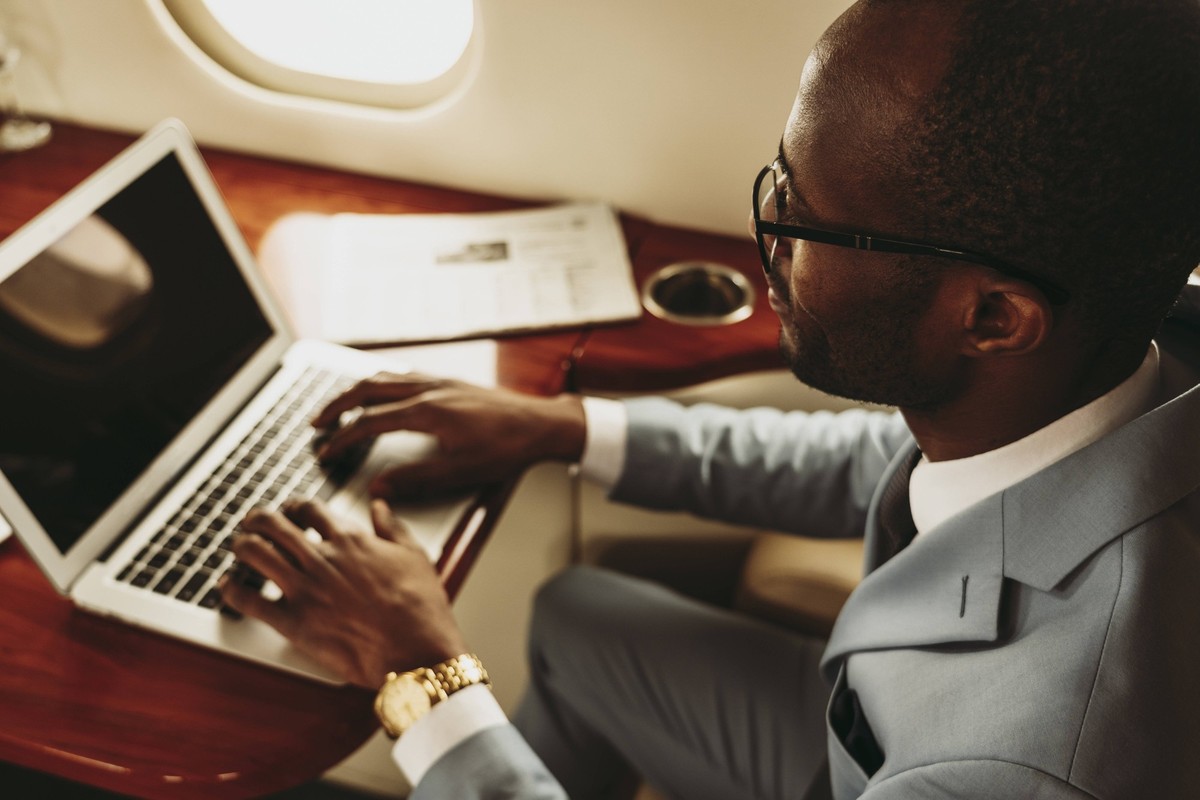 Male entrepreneur typing on laptop in airplane model released Symbolfoto property released OIPF00288