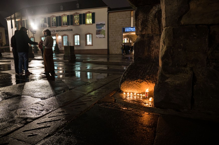 01.12.2020, Rheinland-Pfalz, Trier: Menschen haben an der Porta Nigra Kerzen angez