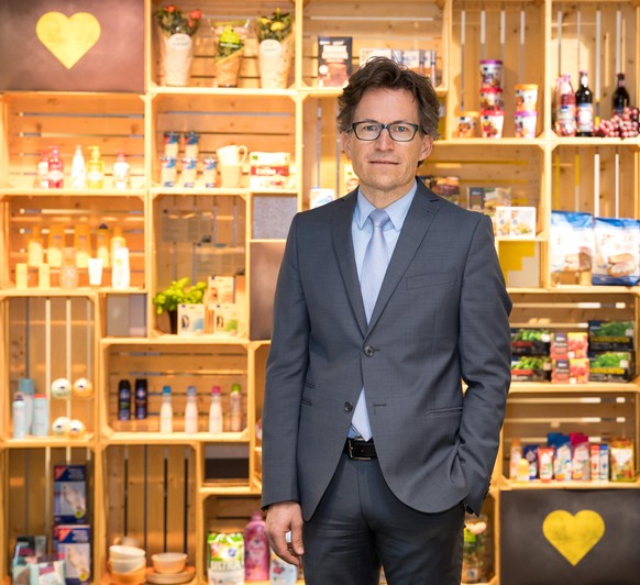 17 April 2018, Hamburg, Germany: Markus Mosa, CEO of the Edeka AG, standing in front of the laboratory of ideas of the company&#039;s headquarters in front of a decorated wall with groceries and produ ...