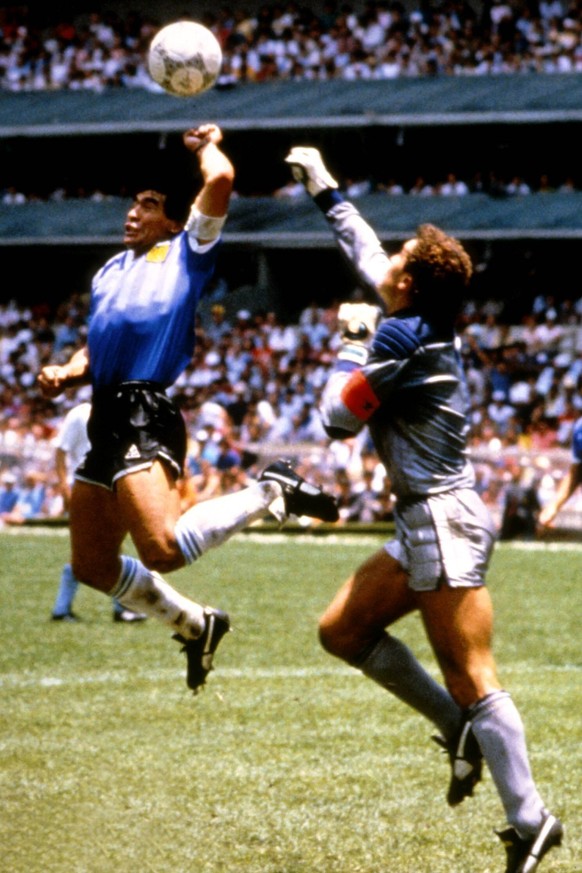 Diego Armando Maradona (li., Argentinien) erzielt gegen Torwart Peter Shilton (England) das 1:0, gegen die Hand Gottes ist der englische Keeper machtlos

Diego Armando Maradona left Argentina reache ...