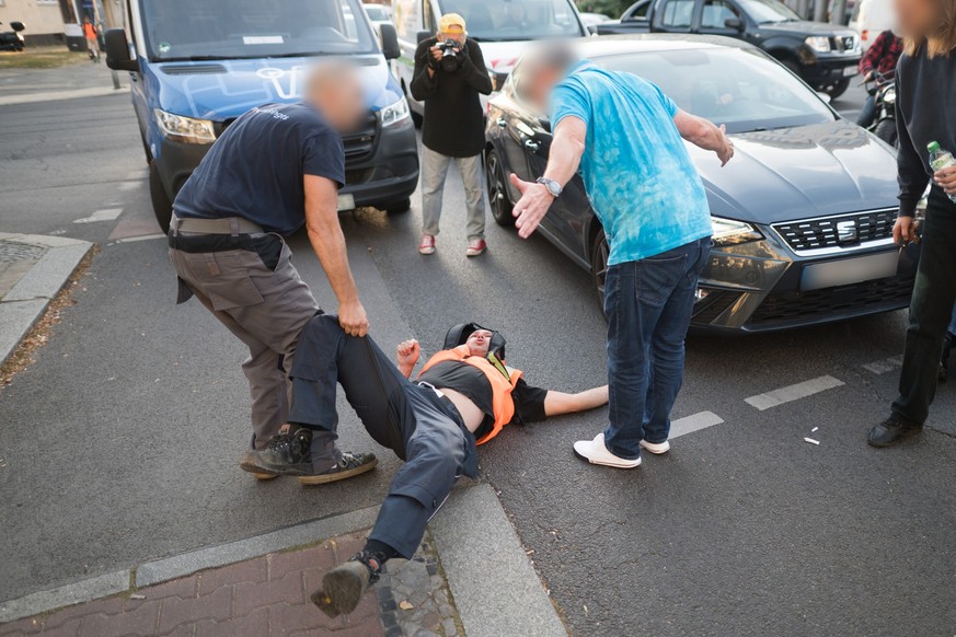 18.09.2023, Berlin: Zwei Autofahrer schreien Aktivisten der Klimaschutzgruppe Letzte Generation während einer Blockade am Spandauer Damm an. Foto: Sebastian Christoph Gollnow/dpa - ACHTUNG: Person(en) ...