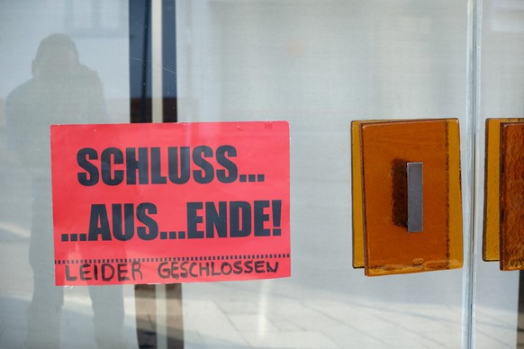 A red sign on the glass doors of a closed department store says &quot;Schluss.... Aus.... Ende! Leider geschlossen&quot; because of the business closing down.