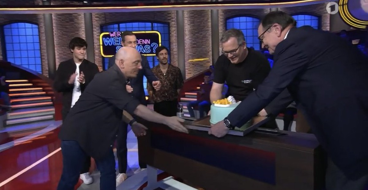 Elton bekommt eine Torte von Ewald Lienen überreicht.